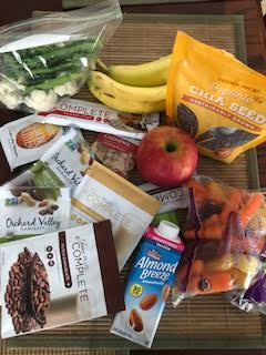 bananas, apples, almond milk, energy bars, mixed nuts and vegetables plus protein powder packets to pack in my suitcase for travel