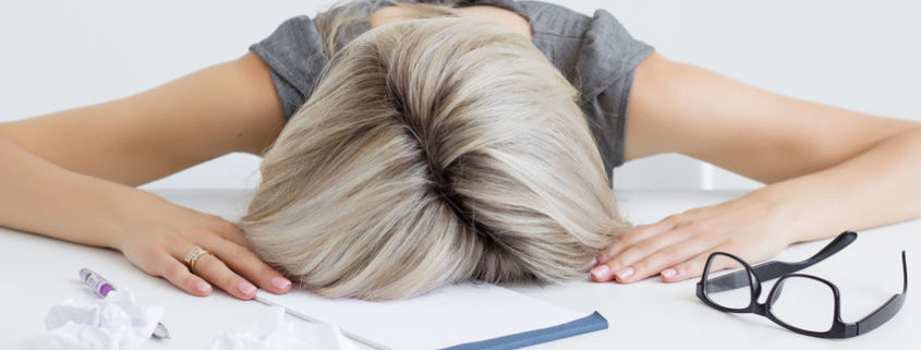 Exhausted Woman's head on desk