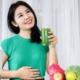 women drinking green drink